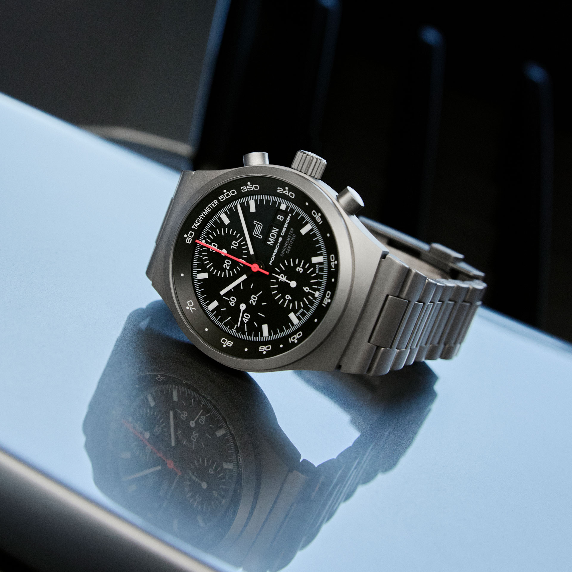 Porsche Design Uhr mit schwarzem Zifferblatt und Mattgrauem Stahlarmband.